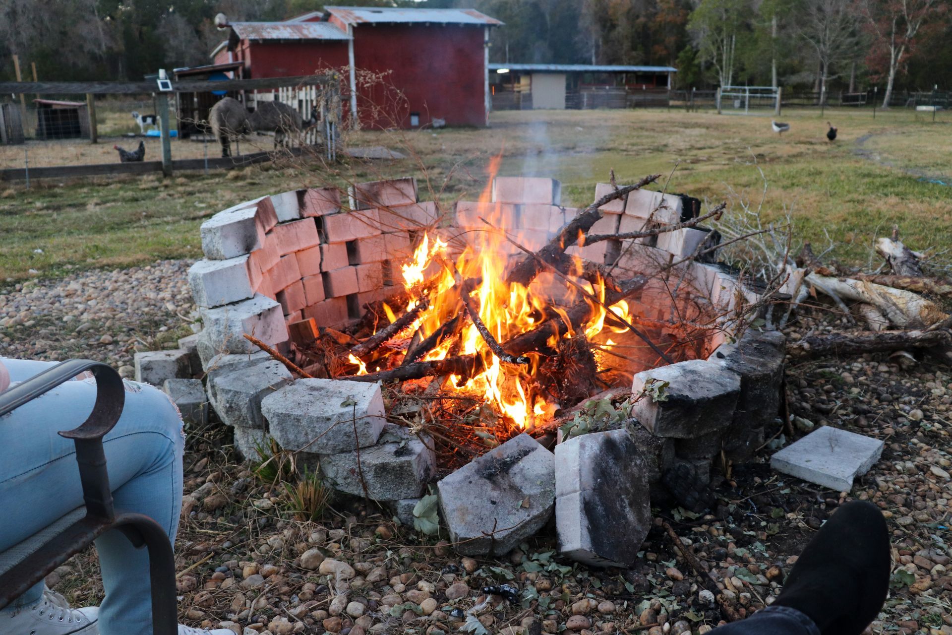 A fire pit with a red barn in the background
