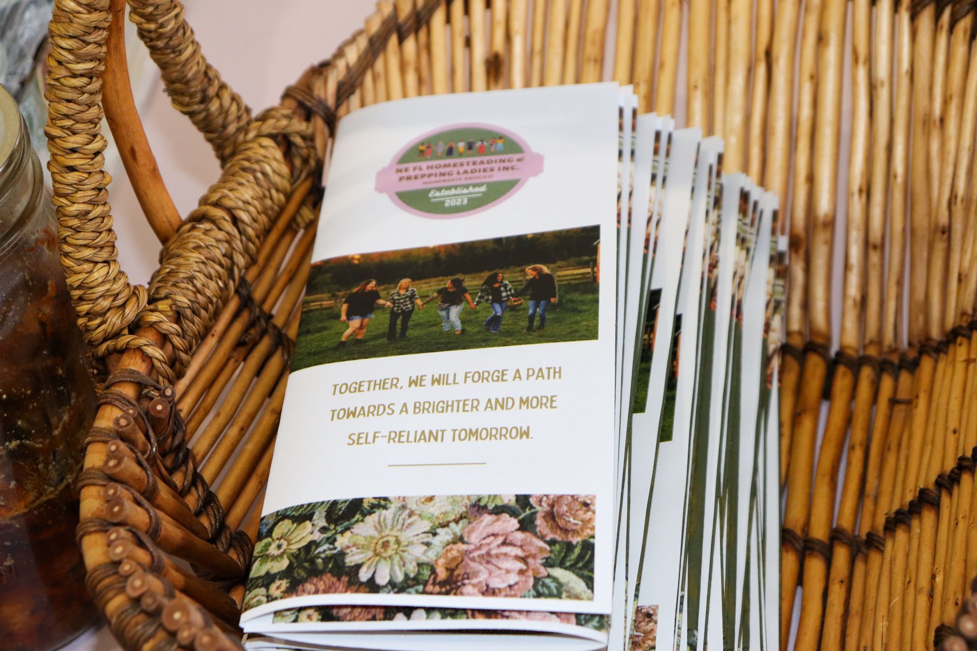 A stack of pamphlets sitting on top of a wicker basket.