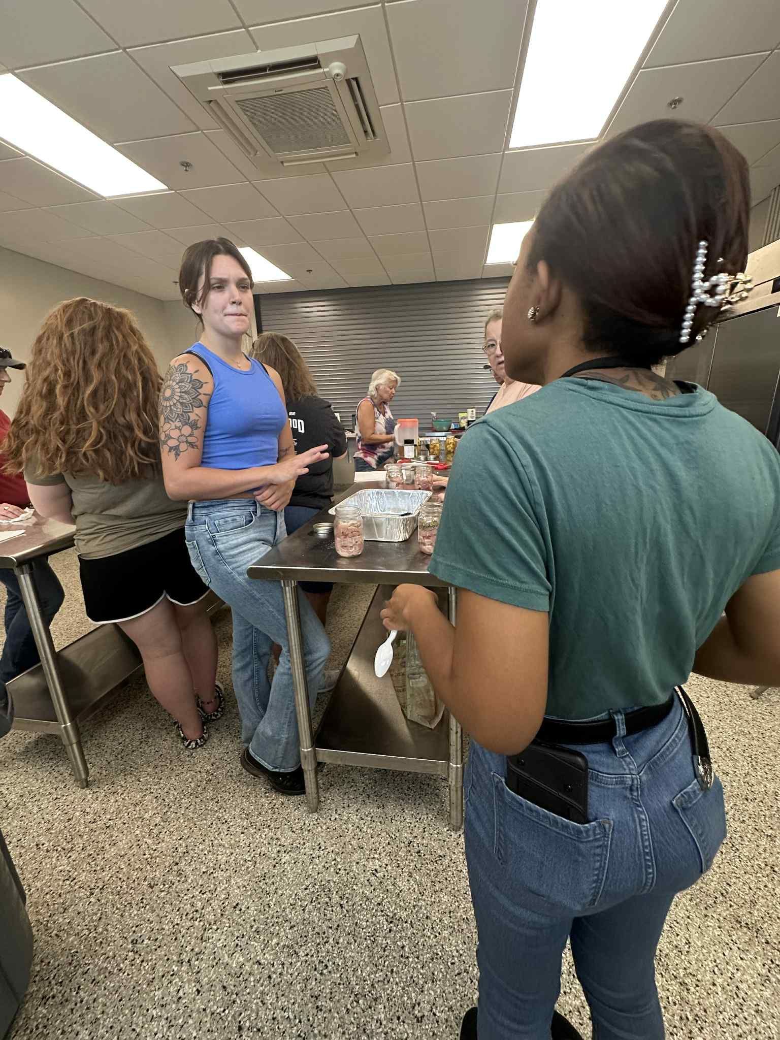 A group of women are standing around a table in a room.