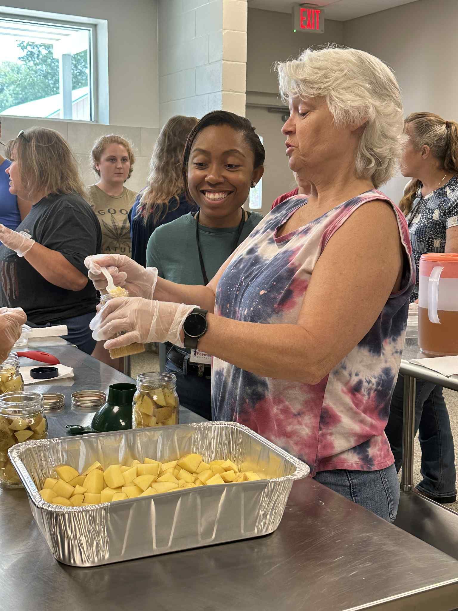 A group of women are preparing food in a kitchen.