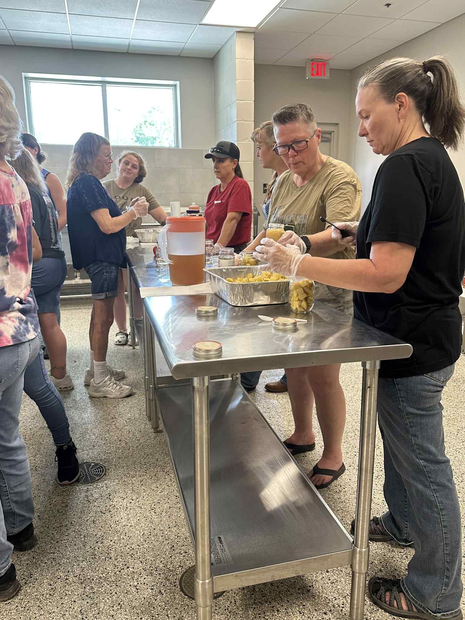 A group of people are standing around a table preparing food.