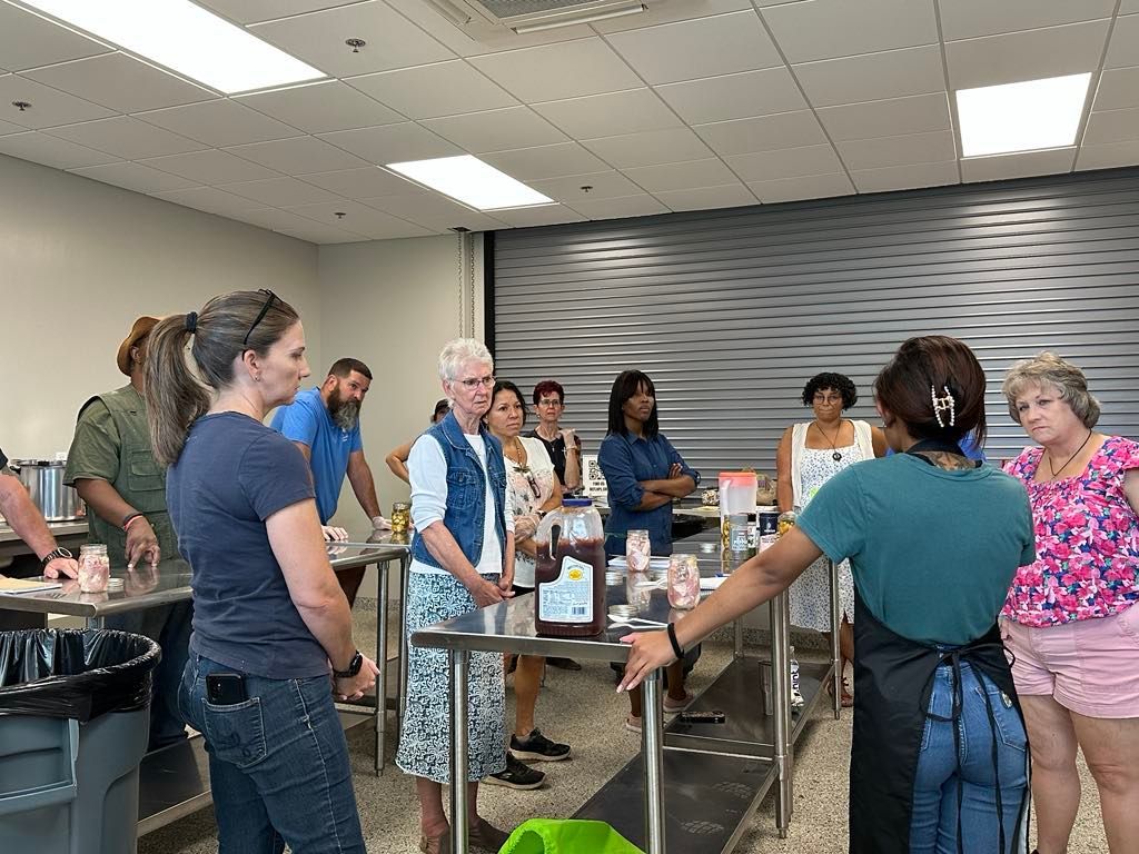 A group of people are standing around a table in a room.