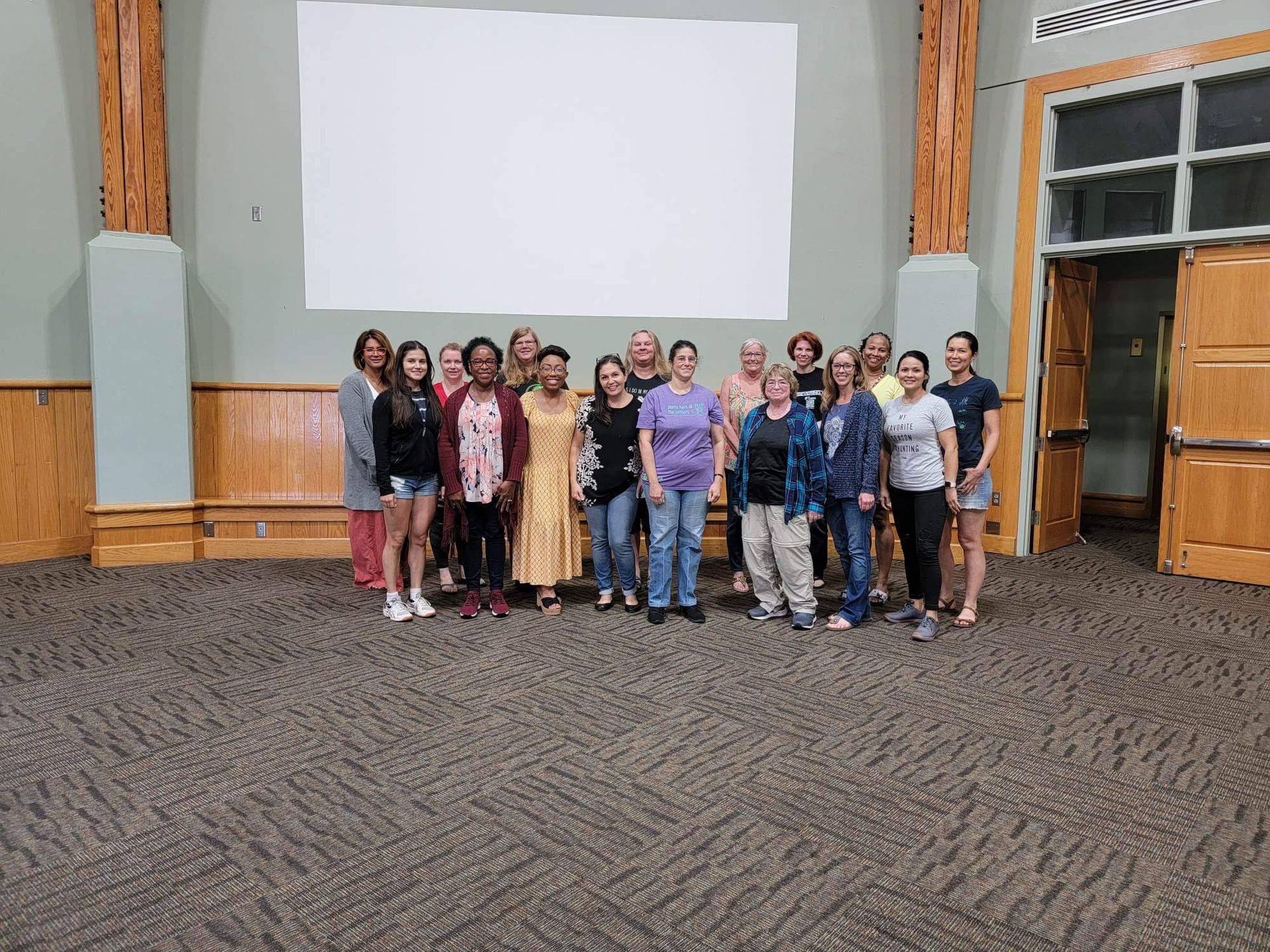 A group of people are posing for a picture in an empty room.