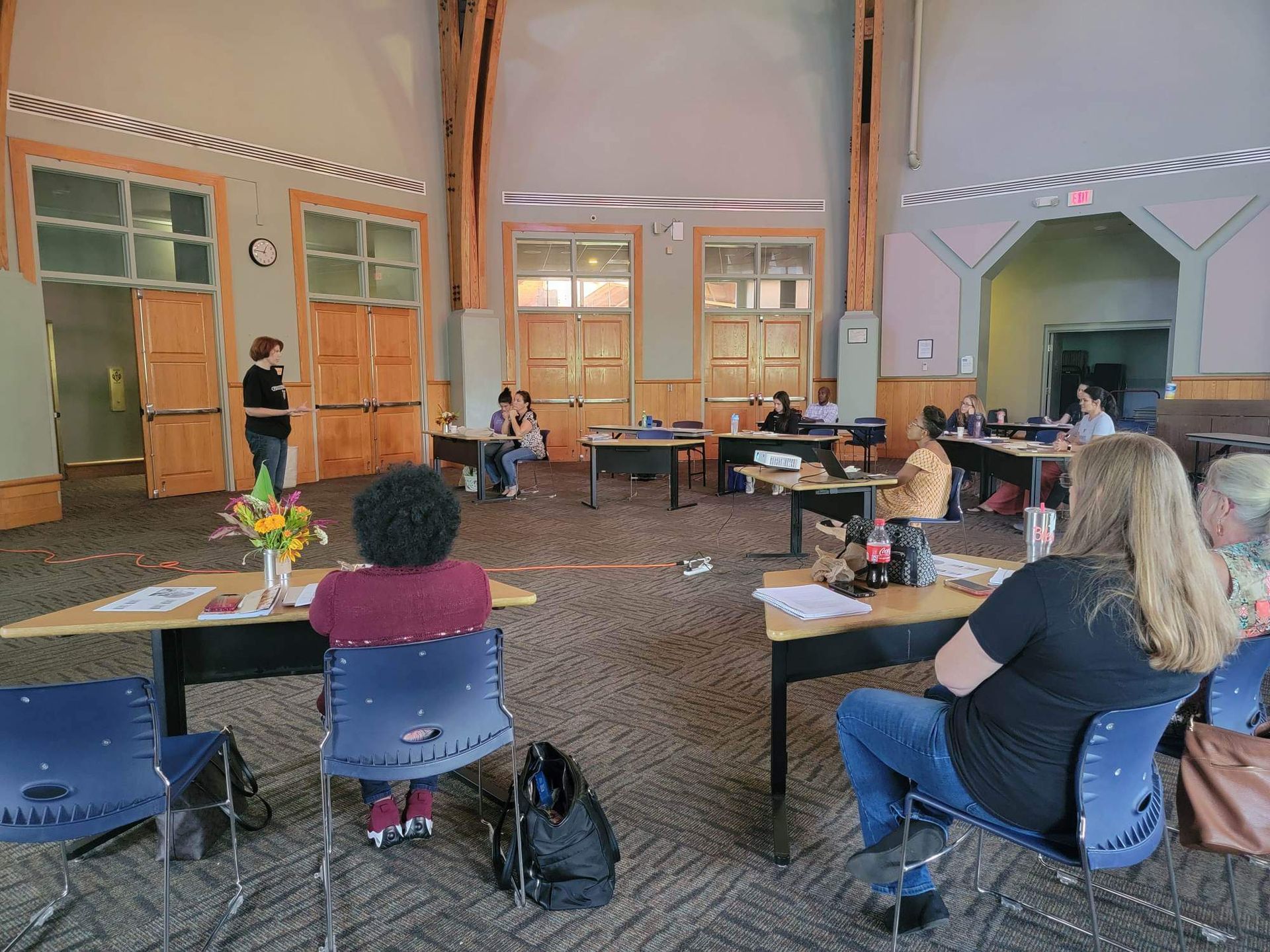 A group of people are sitting at tables in a large room.