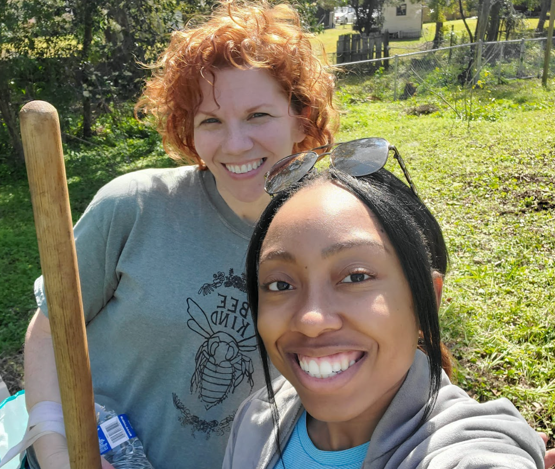 Two women are posing for a picture and one has a shirt that says bee on it