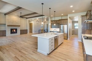 A kitchen with stainless steel appliances and a large island in the middle of the room.