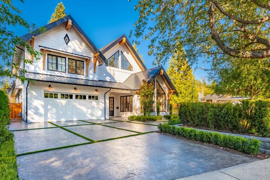 A large white house with a large driveway in front of it.