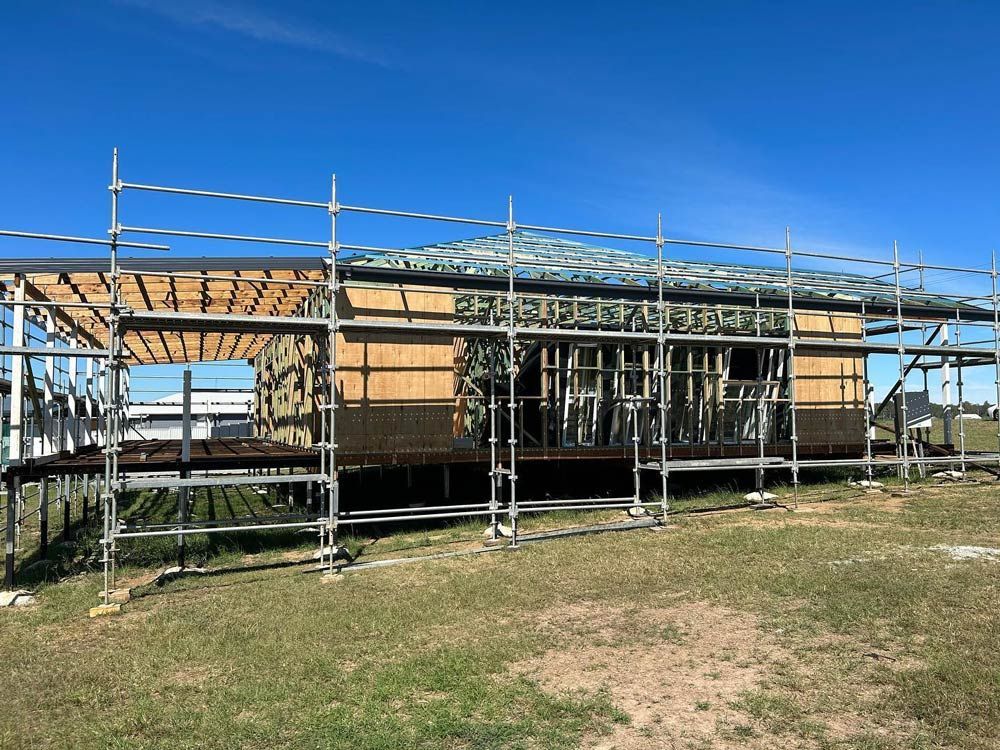 House is Being Built In A Field With Scaffolding Around It — Builder In Gympie, QLD