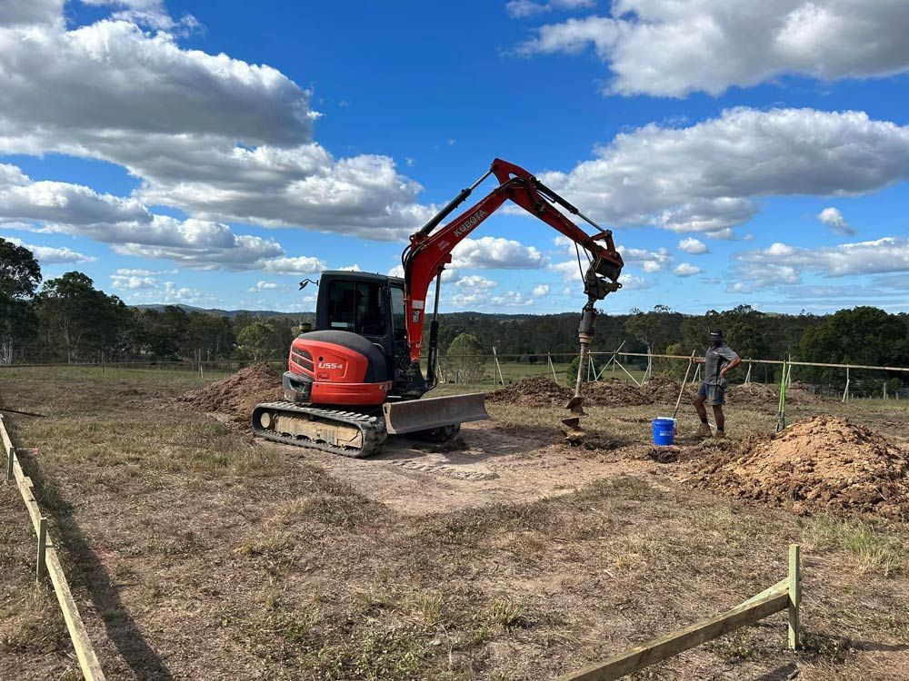 A Red and Black Excavator Skilfully Digs a Hole on The Classic Queensland Homes Website — Builder In Gympie, QLD