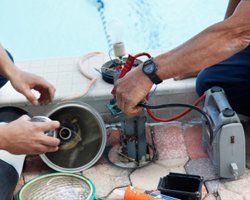 Workers fixing swimming pool equipment