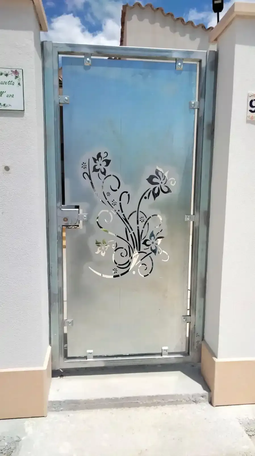 Cancello in metallo con motivo floreale inciso.