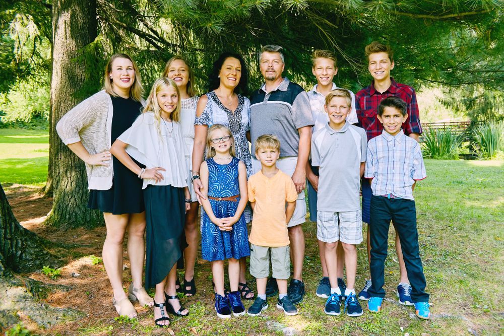A large family is posing for a picture in a park.