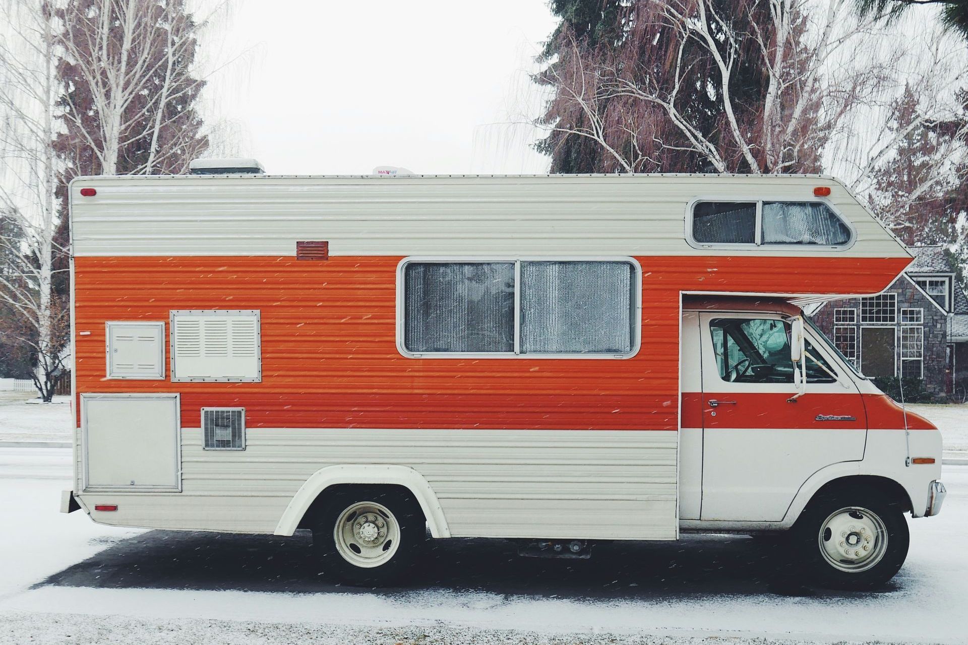 A red and white rv is parked in the snow