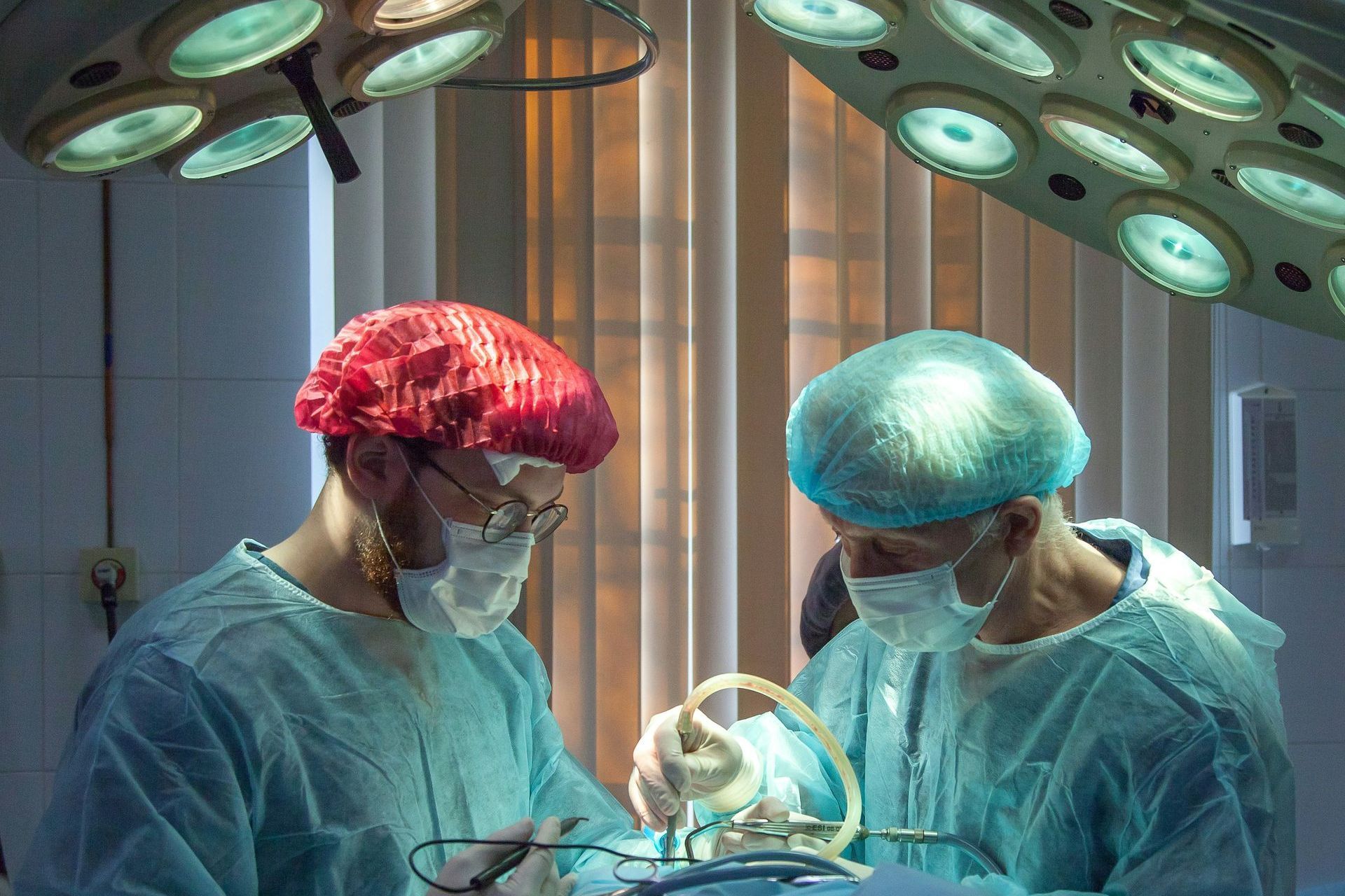 Two surgeons are operating on a patient in an operating room