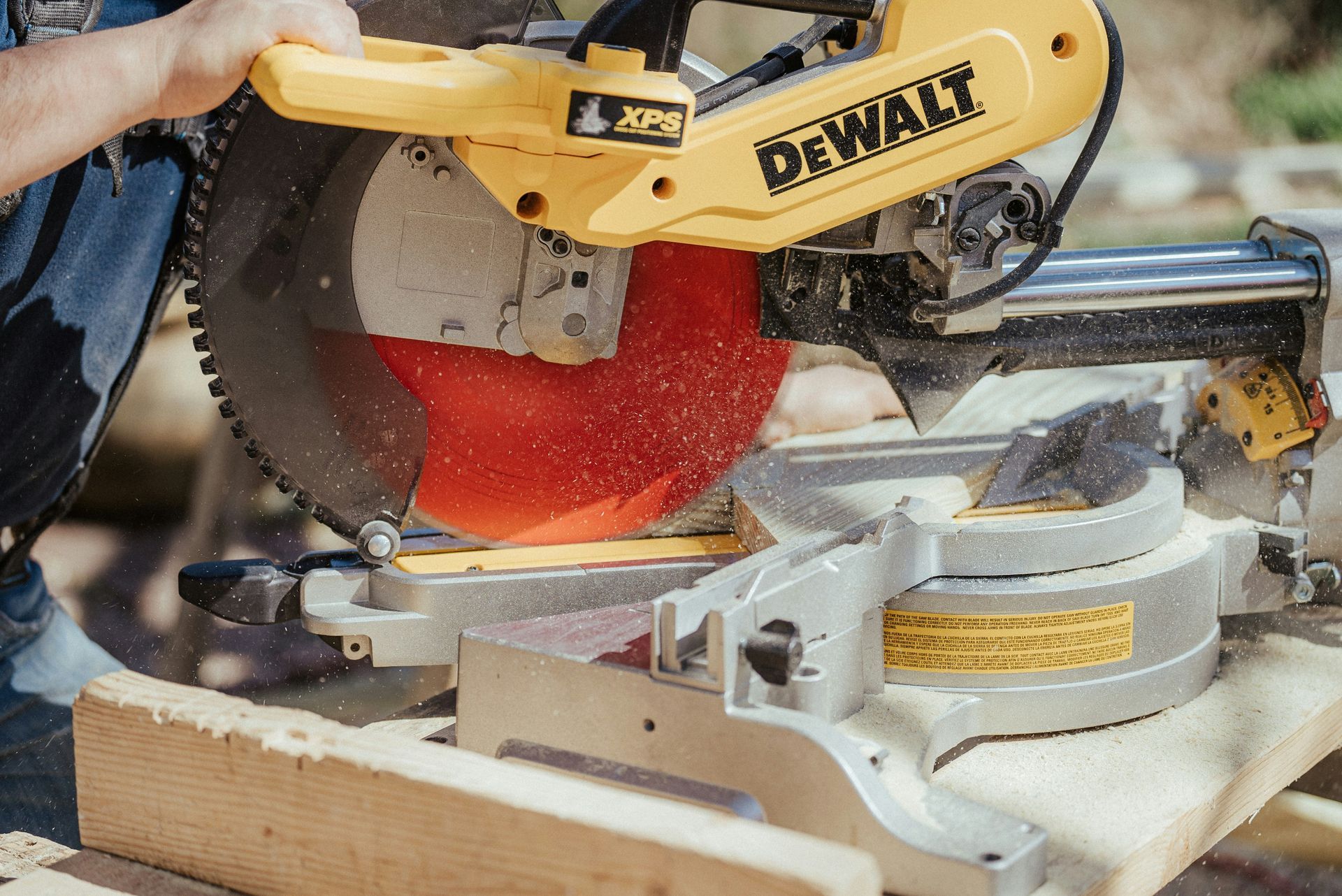 A man is using a dewalt circular saw to cut a piece of wood.