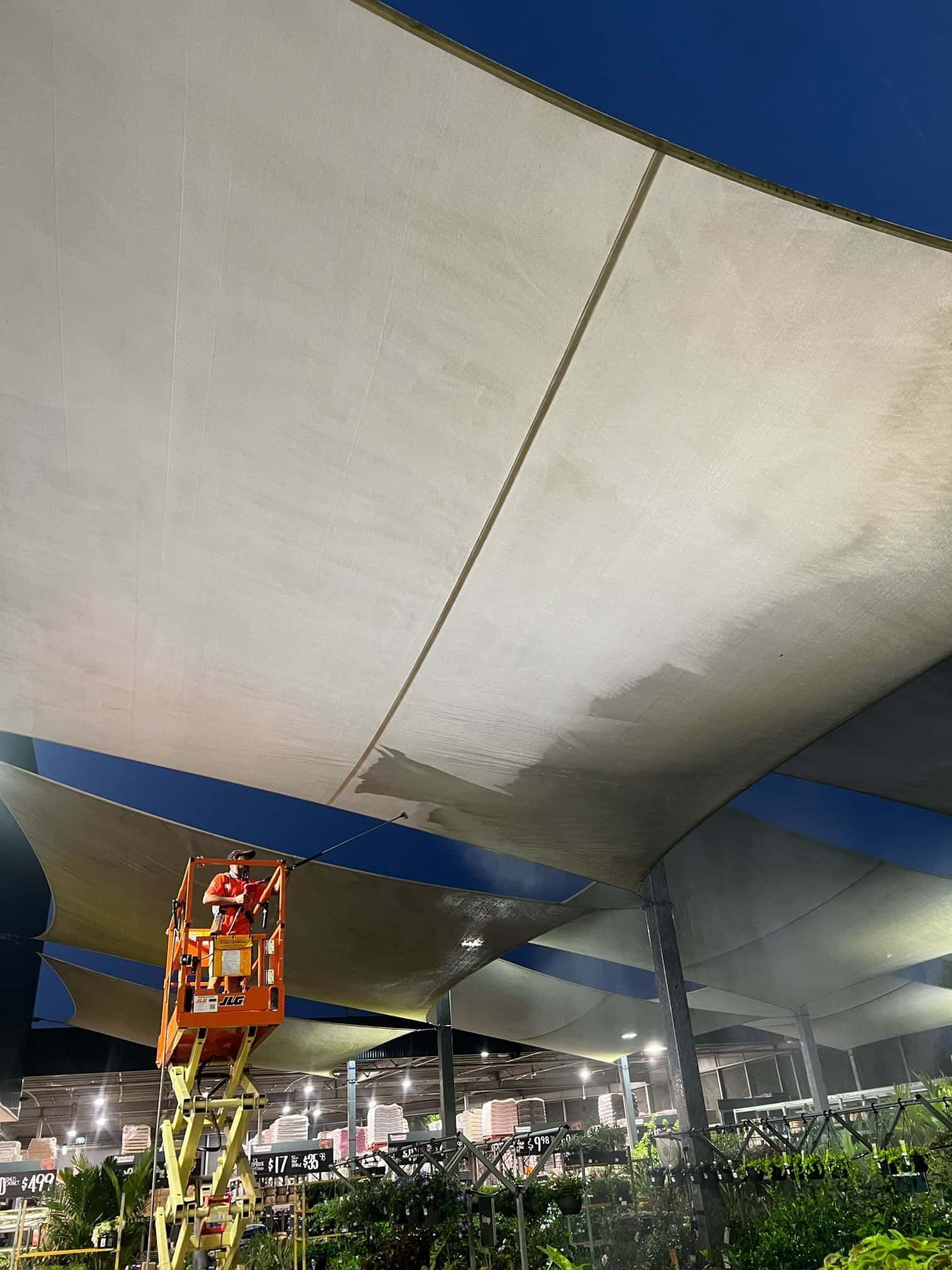 A man is standing on a crane under a canopy. — Hard Surface Cleaners in Clayton, VIC
