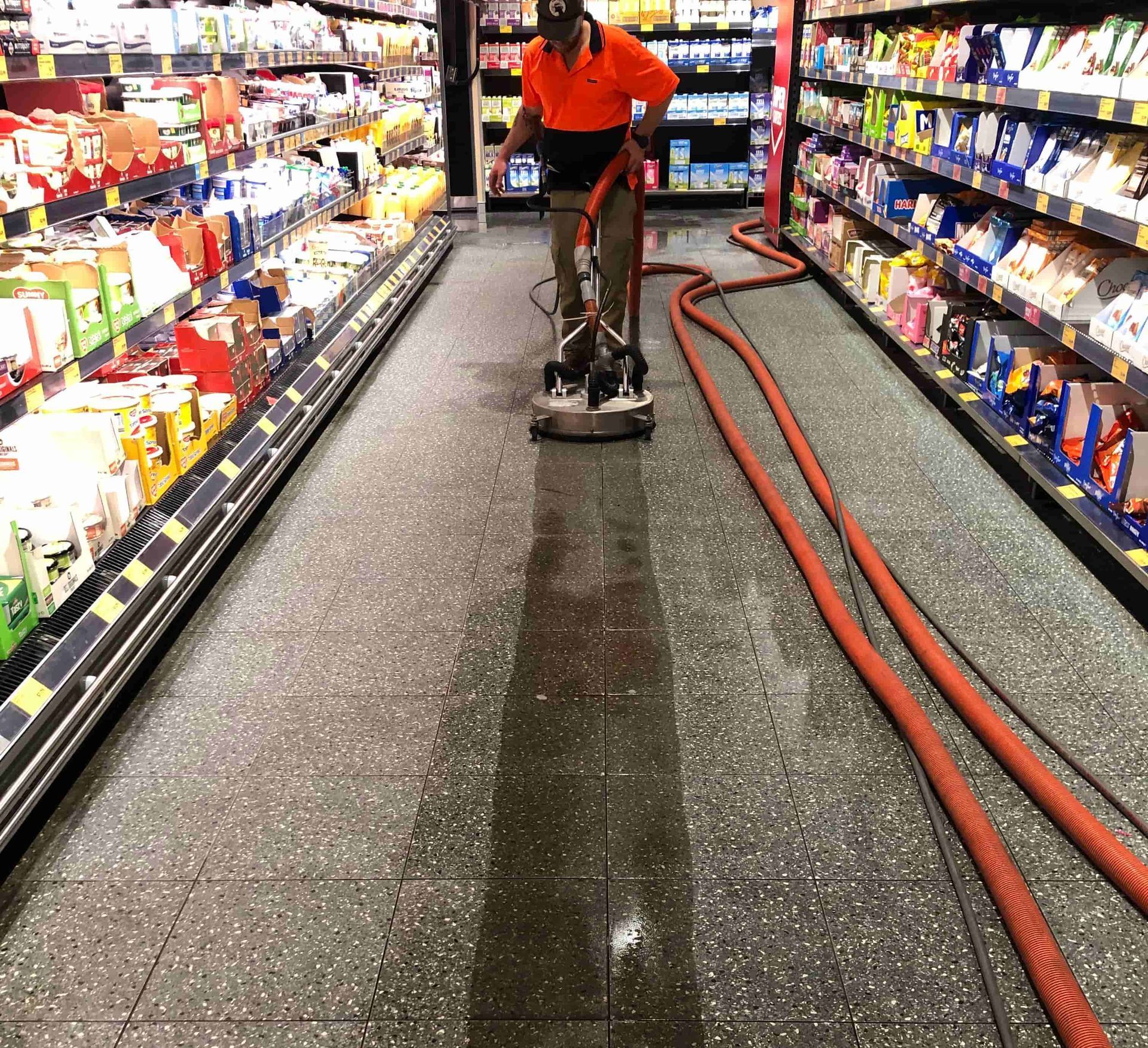 A man is cleaning the floor of a grocery store. — Hard Surface Cleaners in Clayton, VIC