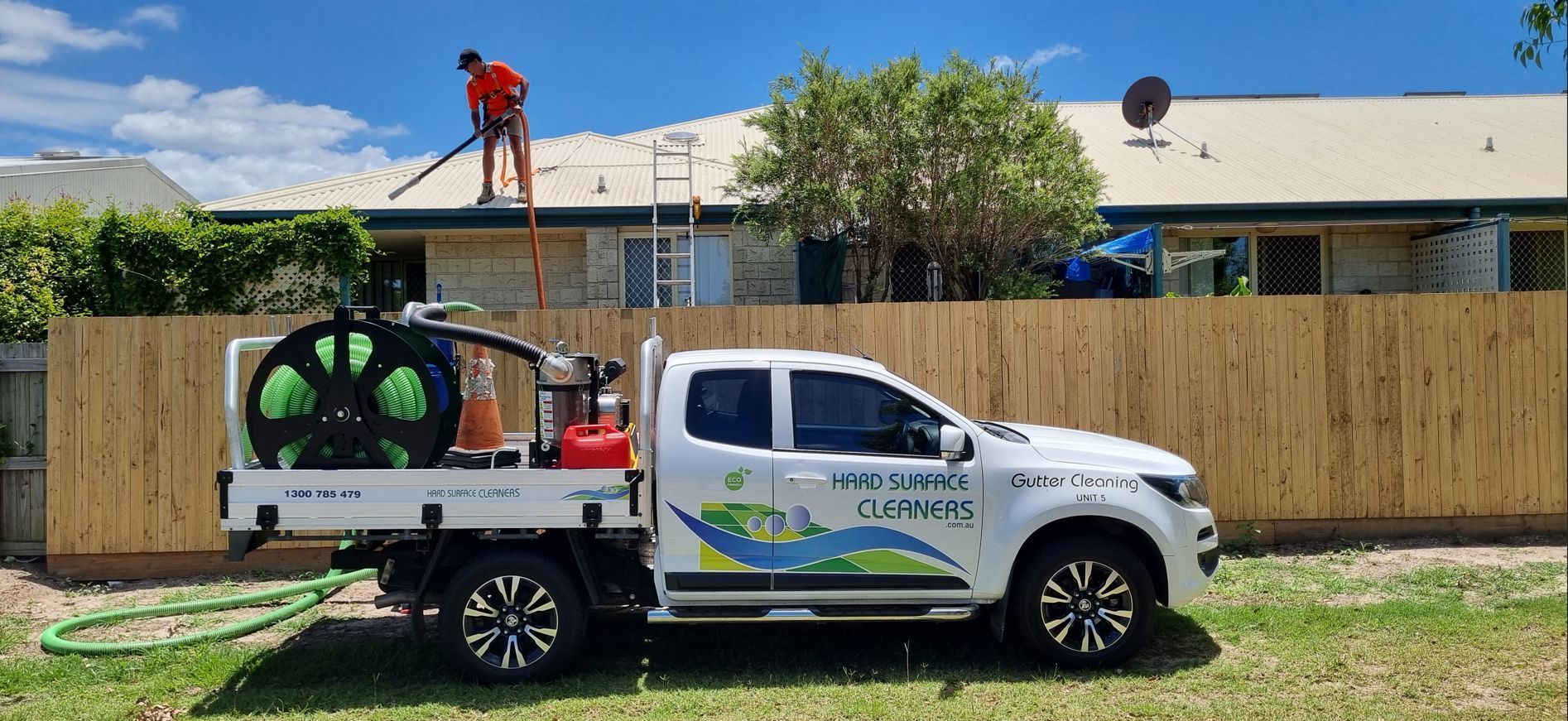 A man is cleaning the roof of a building with a machine. — Hard Surface Cleaners in Clayton, VIC