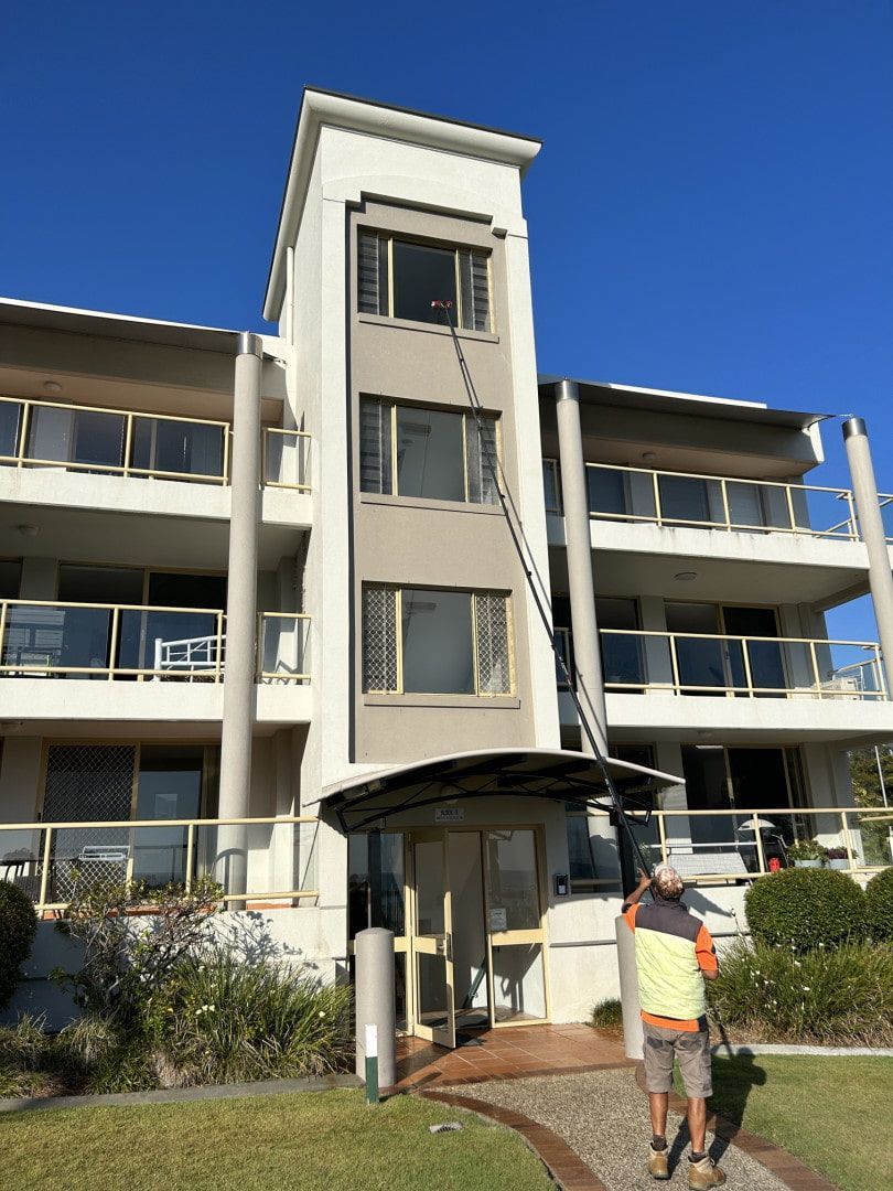 A man is standing in front of a large building. — Hard Surface Cleaners in Clayton, VIC