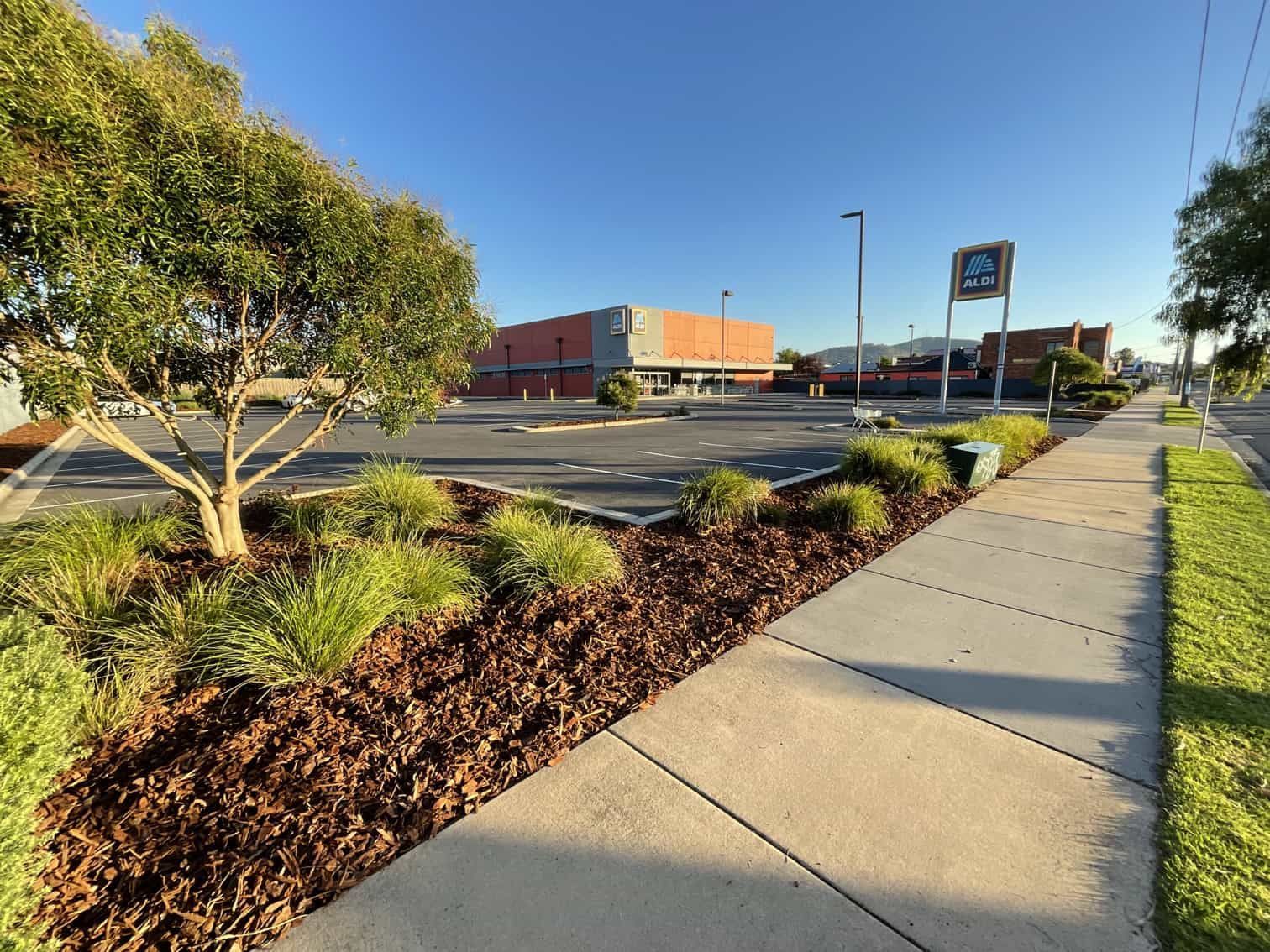 A sidewalk leading to a parking lot with a store in the background — Hard Surface Cleaners in Clayton, VIC