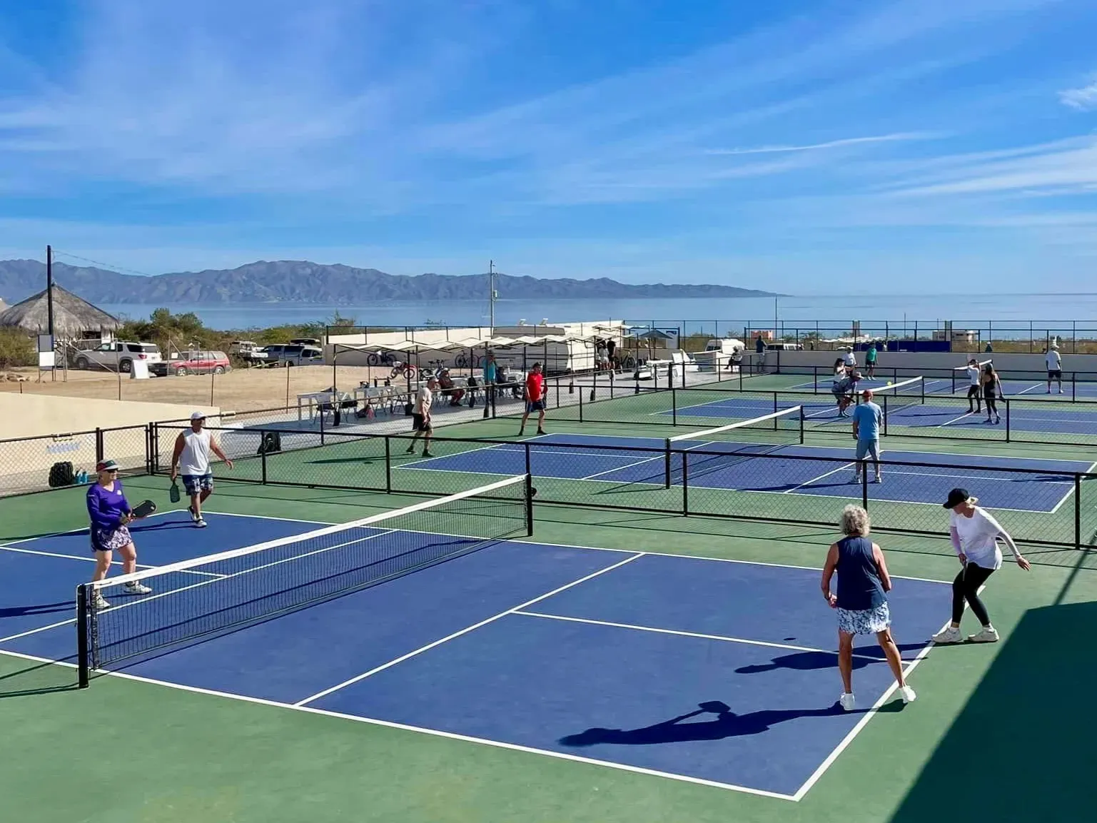 Scuba diver swimming underwater, exhaling bubbles; bright blue water, coral reef.