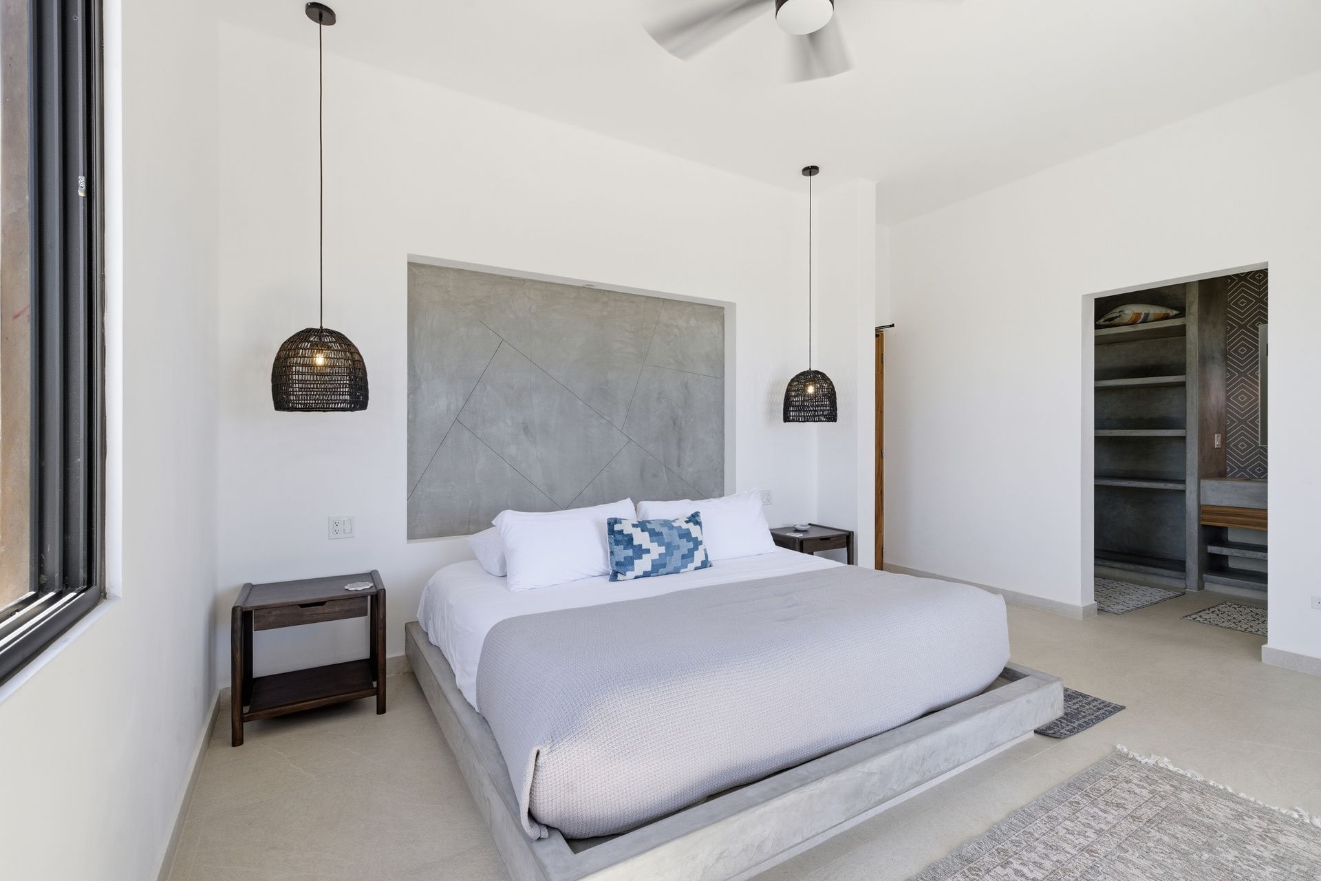 Bedroom with gray bed frame, textured headboard, black pendant lights, and closet.