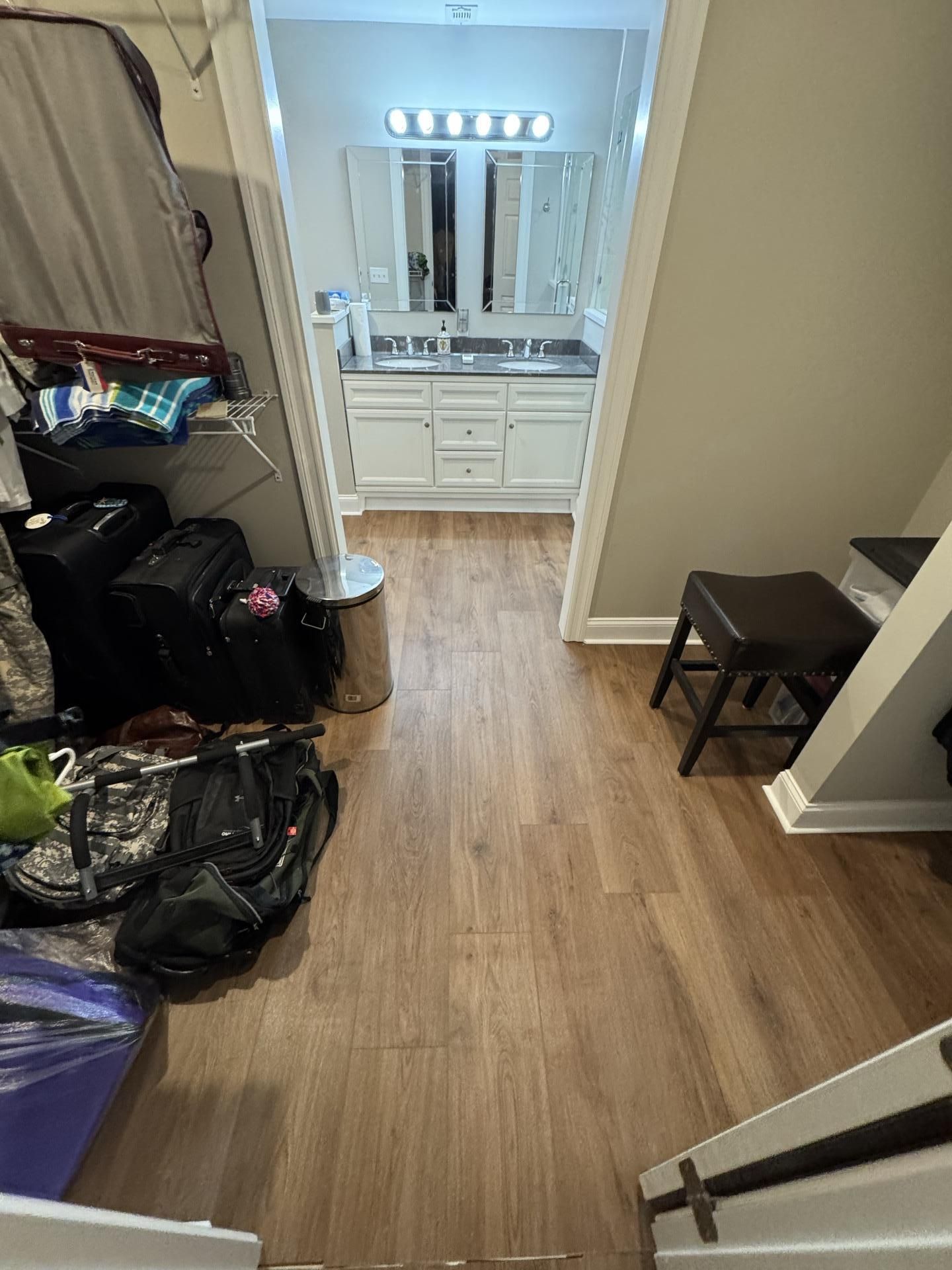 A view from a room looking into a bathroom with a white vanity and double mirrors.