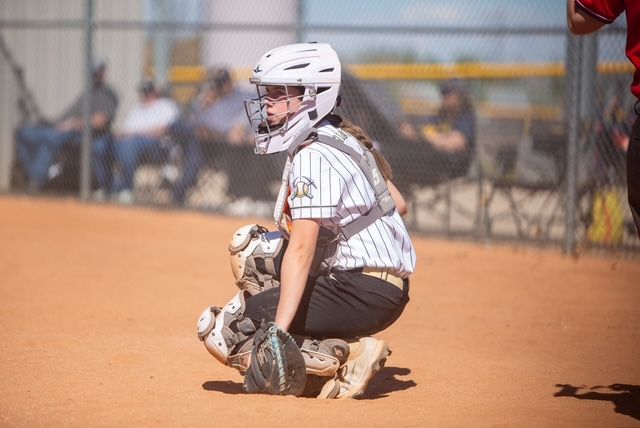 Baseball player sliding into home plate, catcher in front. Blue and gold uniforms, action shot.