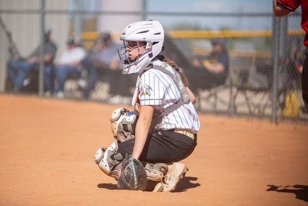Baseball player sliding into home plate, catcher in front. Blue and gold uniforms, action shot.