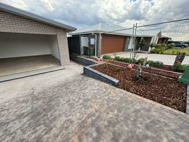 A detached garage and house with landscaping in front. The garage is open — Darlington Landscaping in Nyngan, NSW