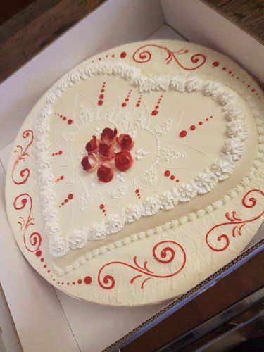 Torta di celebrazione con un cuore bianco e decorazione con sciroppo di fragole