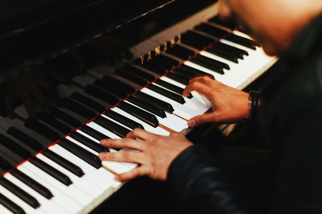 An adult playing a piano.