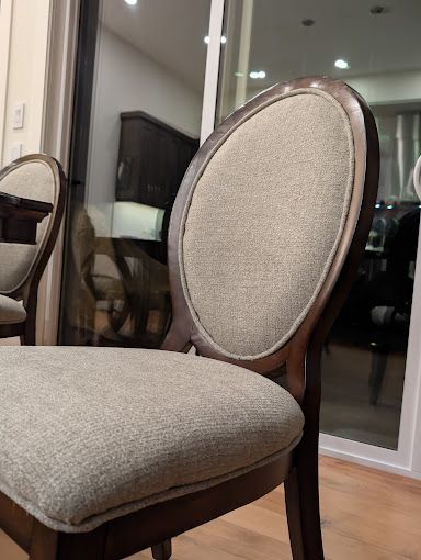 Upholstered dining chair with oval back and light brown seat; dark wood frame.