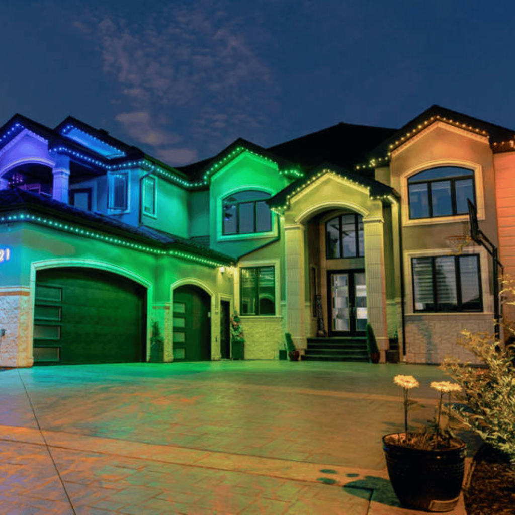 House with colorful LED lights lining the roof and windows at dusk, with a rainbow effect.