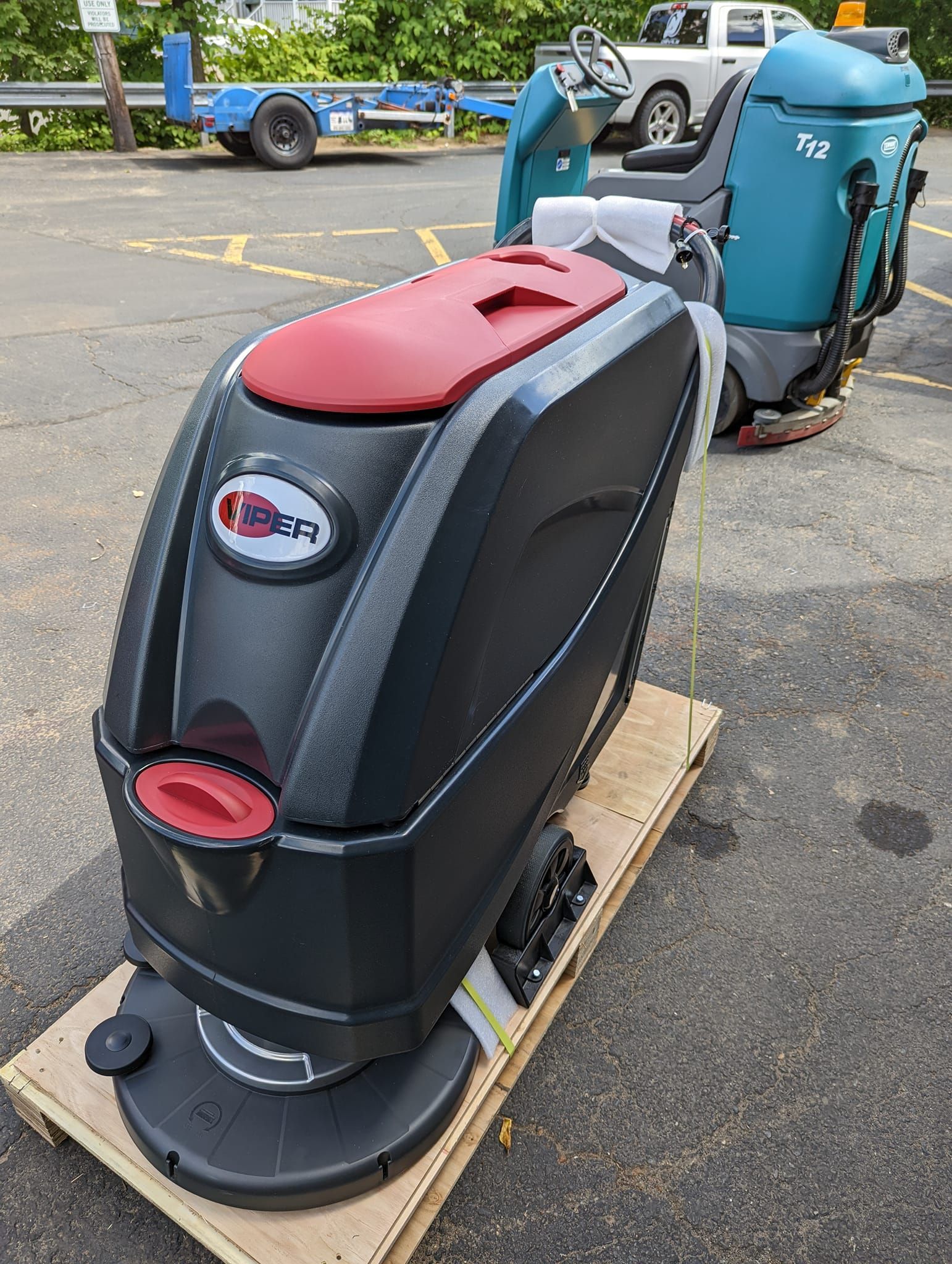 A black and red machine is sitting on top of a wooden pallet.