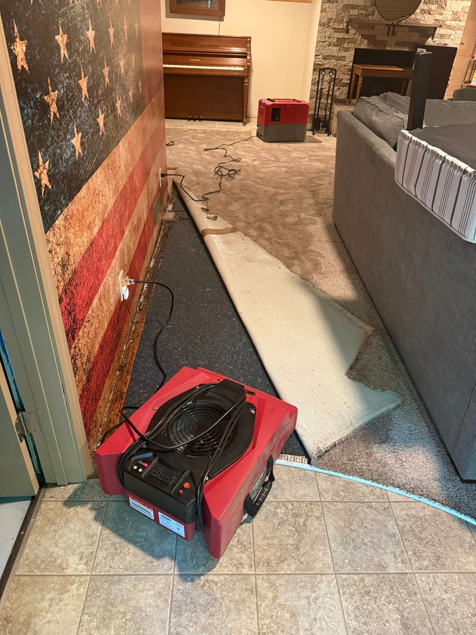 Red fan and removed flooring in a room with an American flag mural.