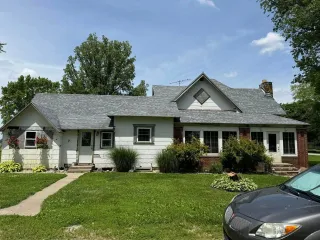 Person using a hose to vacuum a wet floor with red equipment. Basement setting.