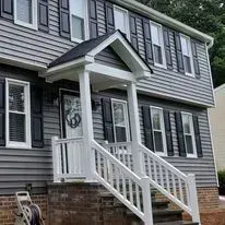 Gray house with white porch and railings.
