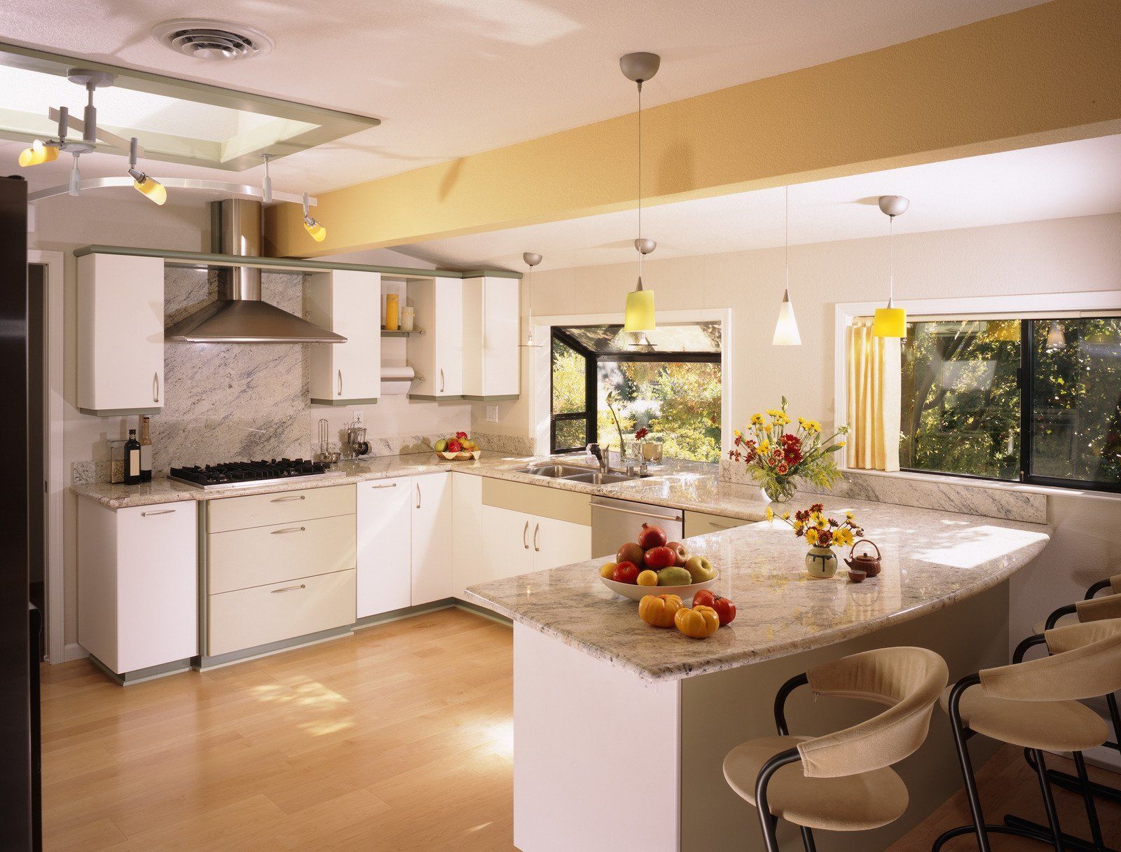 Modern kitchen with white cabinets, granite countertops, and breakfast bar with stools.