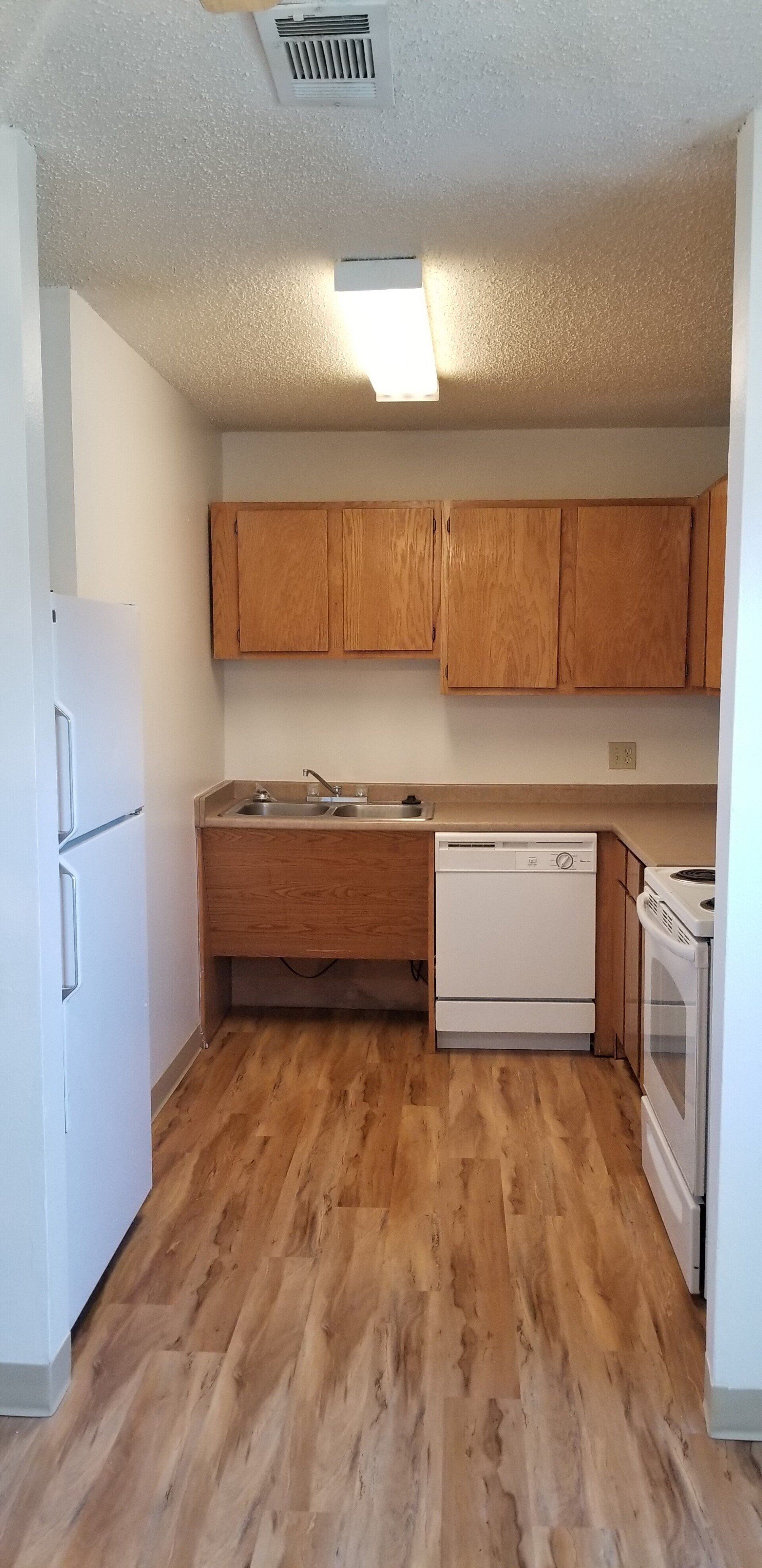 Alternate interior view of kitchen with appliances and cabinetry