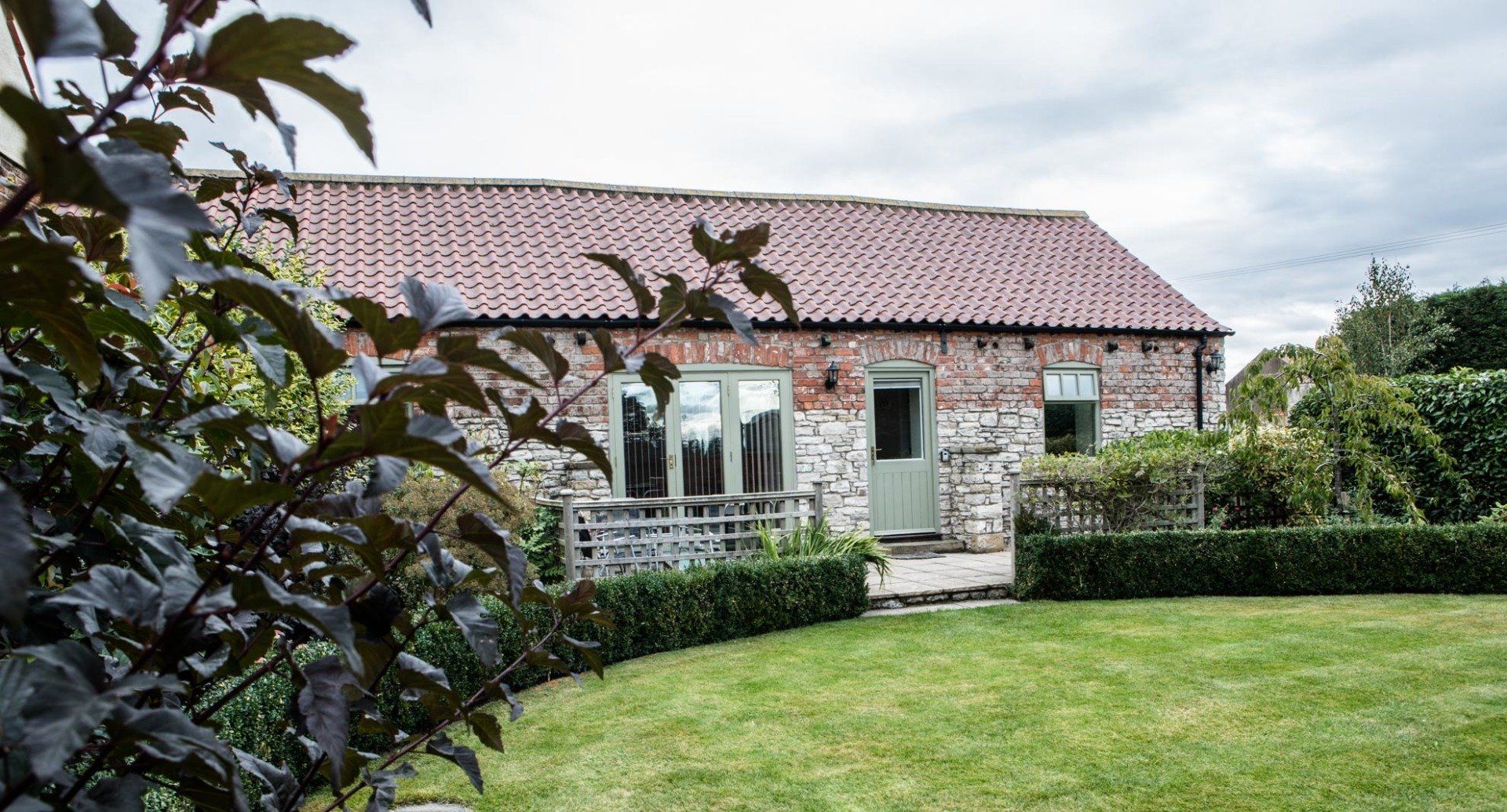 A brick house with a large lawn in front of it.