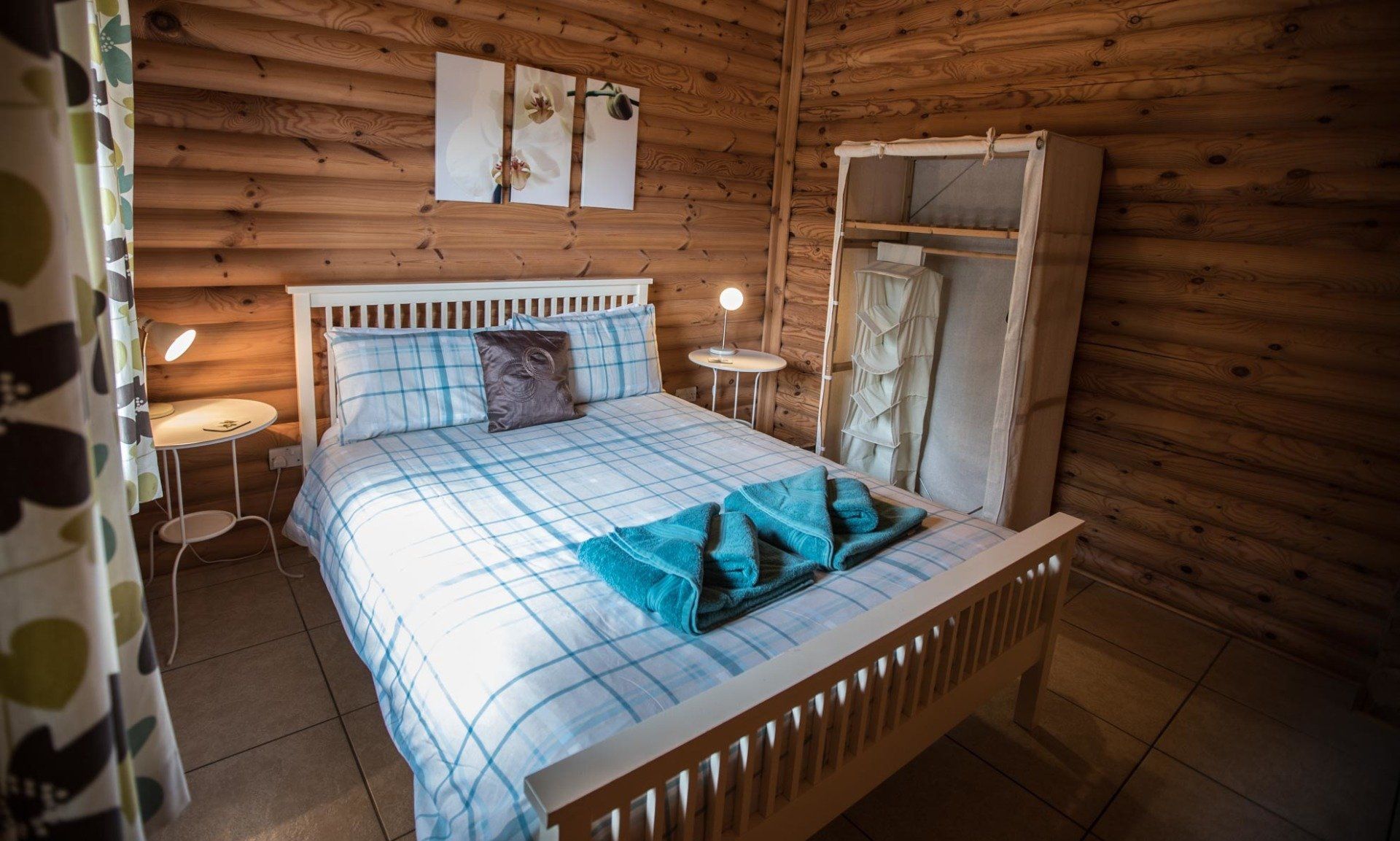 A bedroom in a log cabin with a bed and a wardrobe.