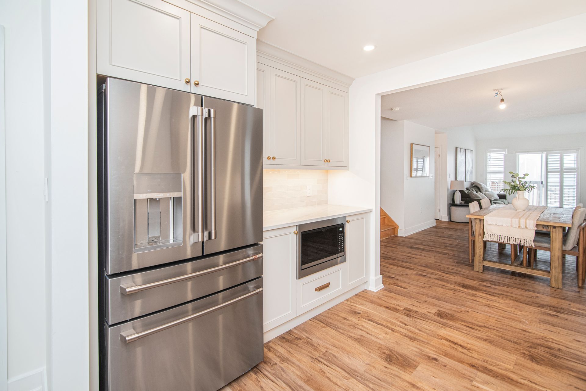 There is a stainless steel refrigerator in the kitchen.