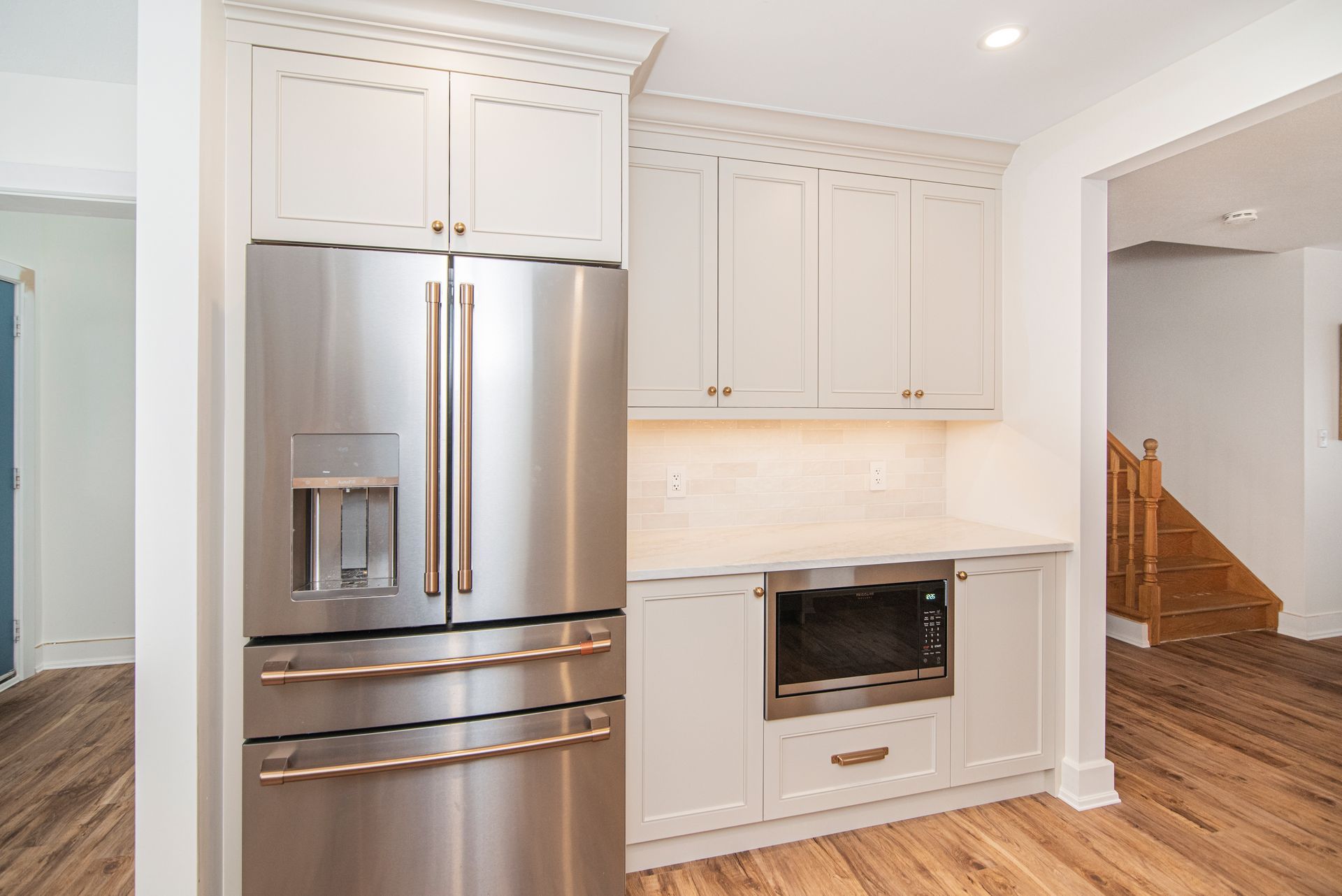 A kitchen with stainless steel appliances and white cabinets.