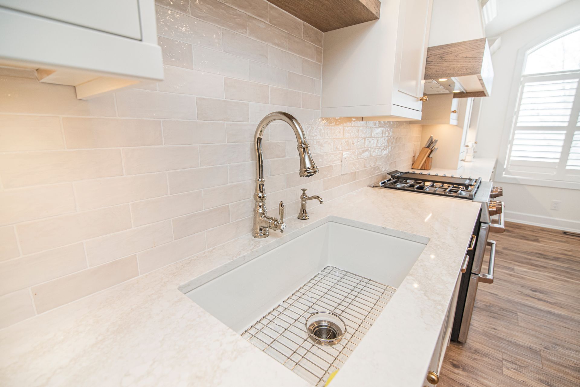 A kitchen with a white sink and a faucet.