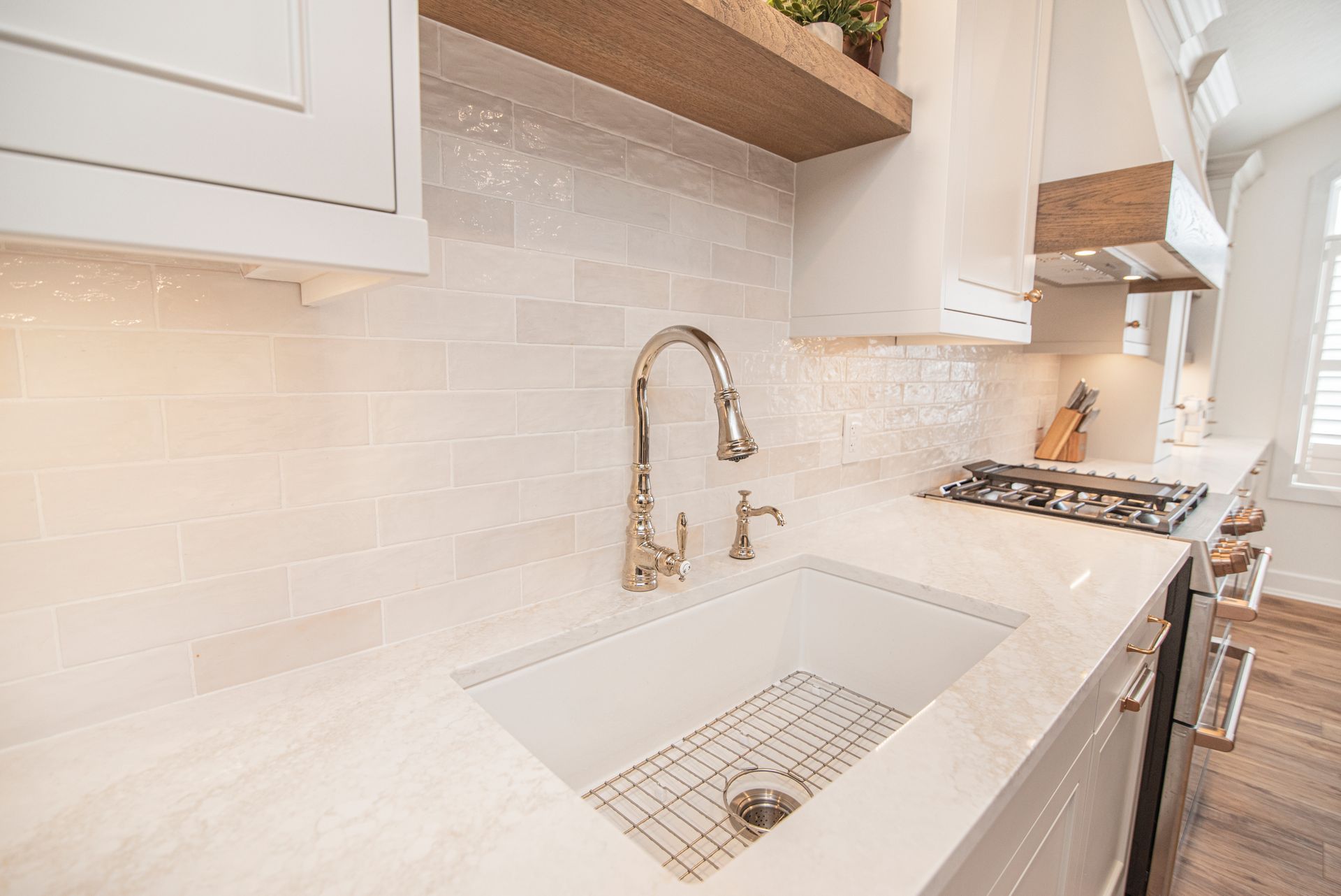 A kitchen with a white sink and a stove top oven.
