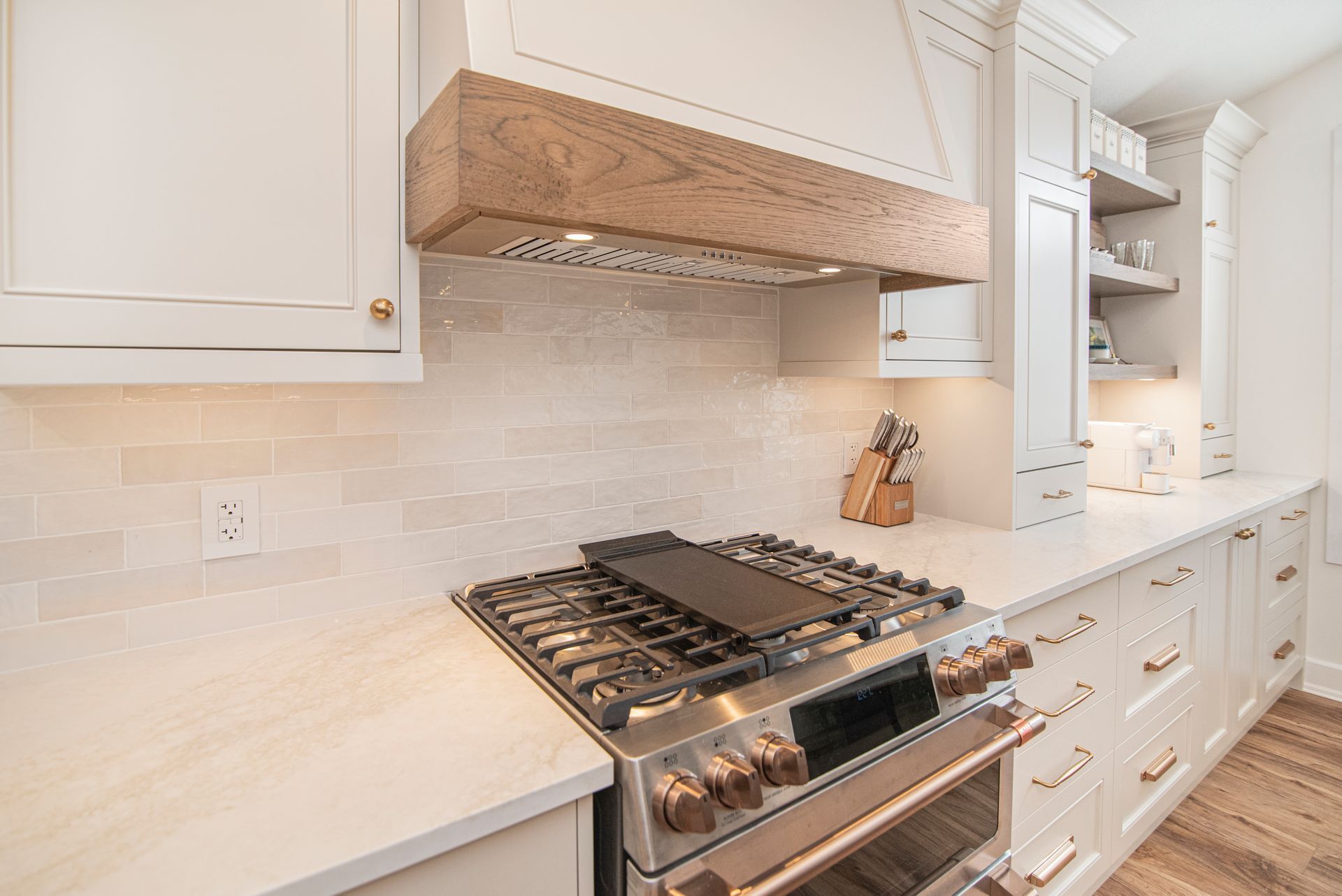 A kitchen with a stove top oven and a wooden hood.