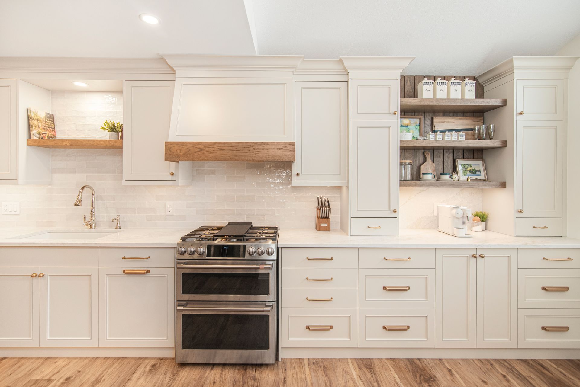 A kitchen with white cabinets , stainless steel appliances , a sink , and a stove.