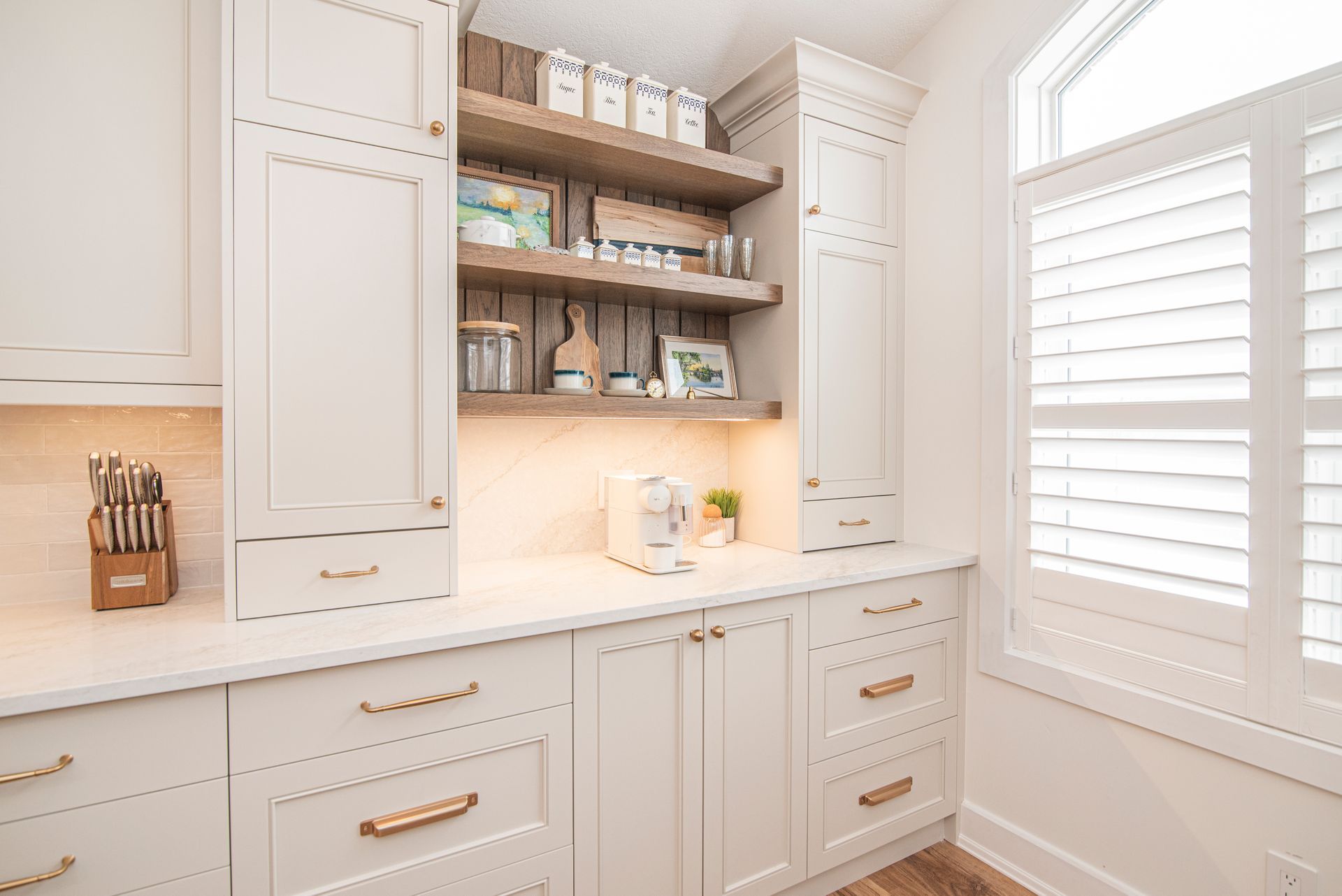 A kitchen with white cabinets , stainless steel appliances , a sink , and a stove.
