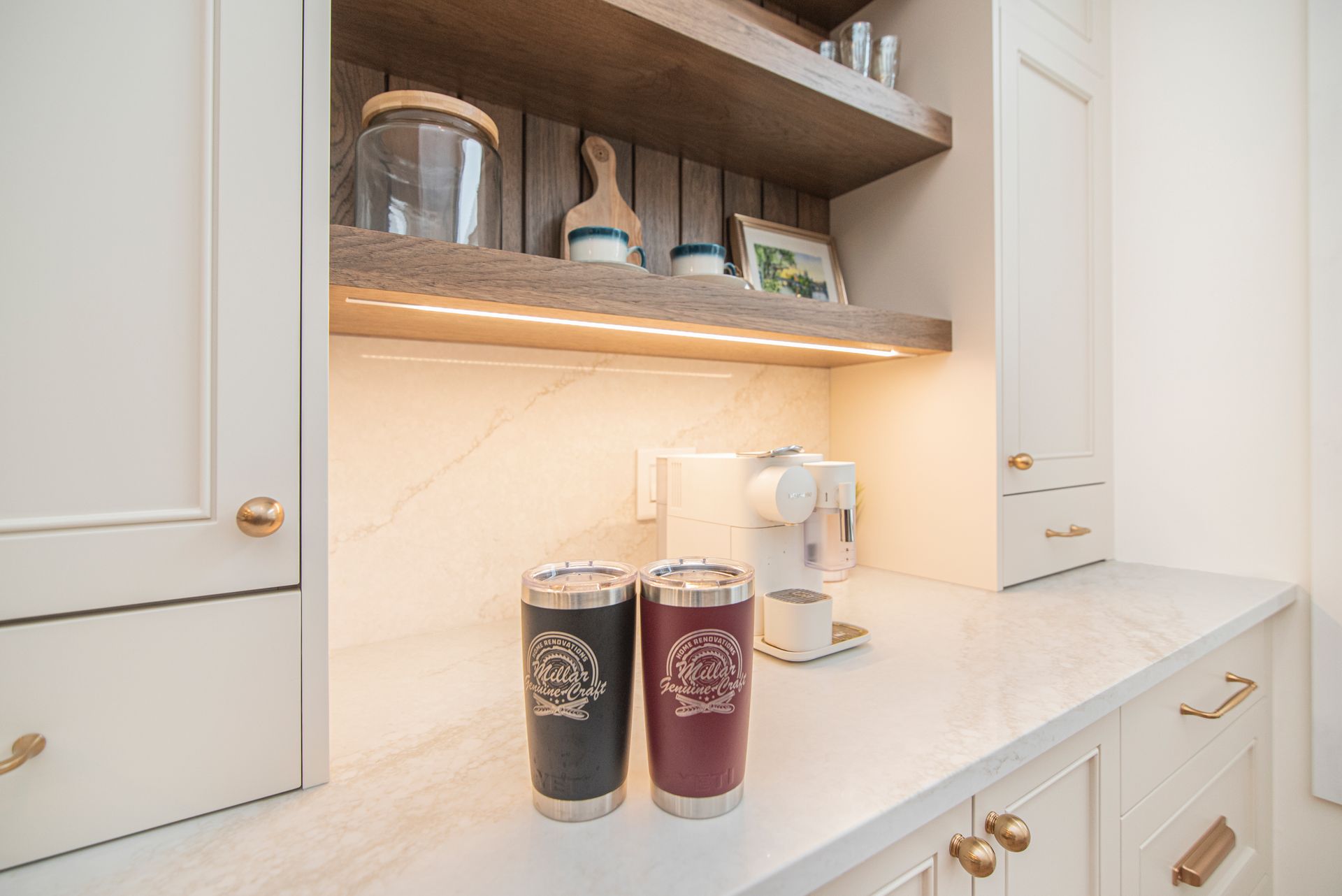 Two cups are sitting on a counter in a kitchen.